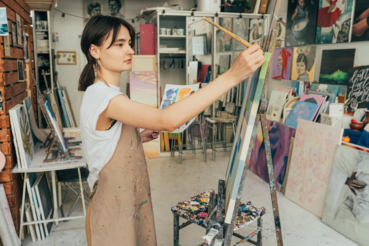 A Woman Painting On A Canvas