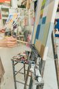 Person Holding Paint Brush Painting on White Blue and Yellow Wall
