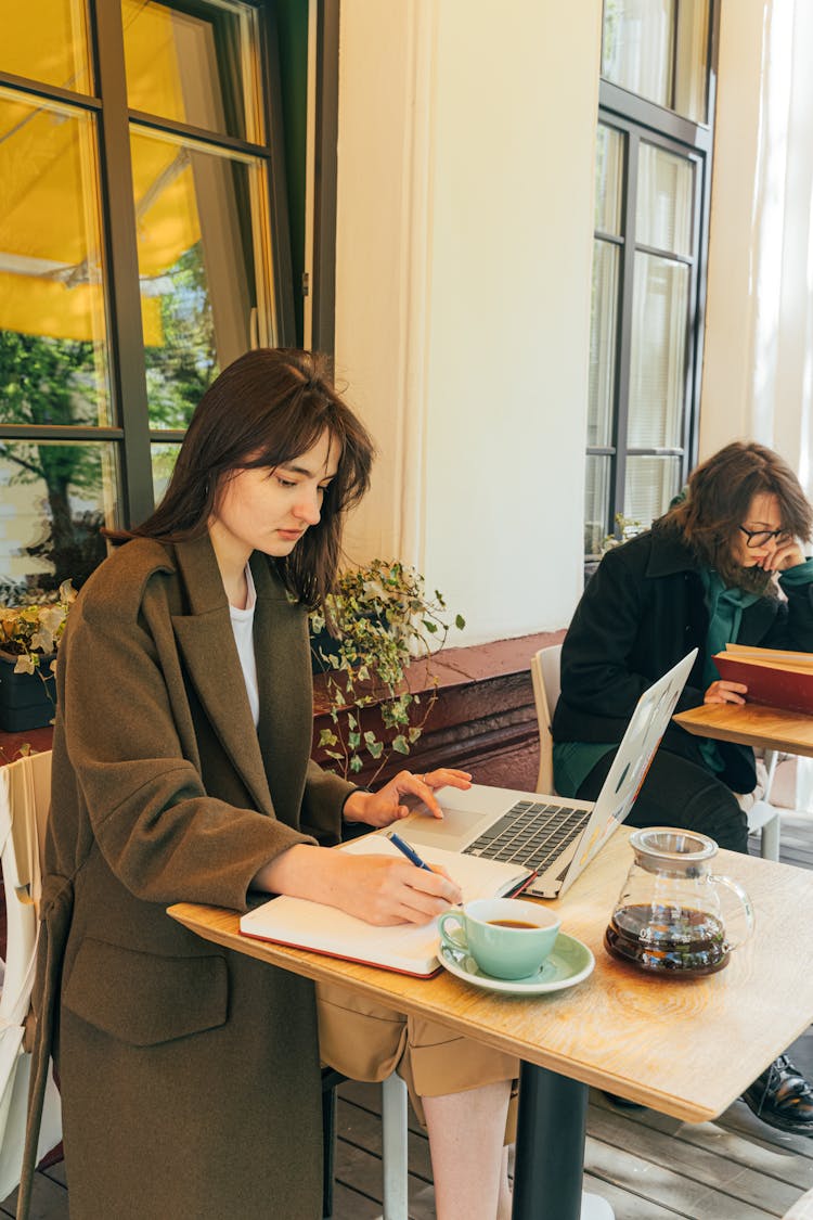 A Woman Working While In The Coffee Shop