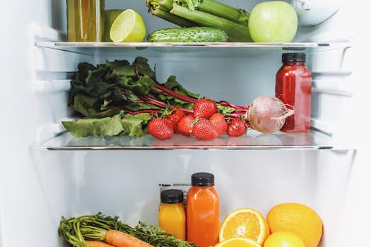 Colorful array of fresh fruits and vegetables neatly arranged in a refrigerator.