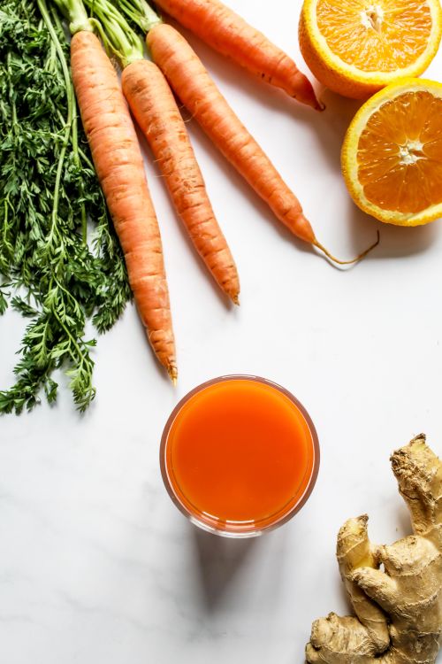 Free Top view of refreshing carrot and orange juice with ginger, shot in a studio setting on a white background. Stock Photo