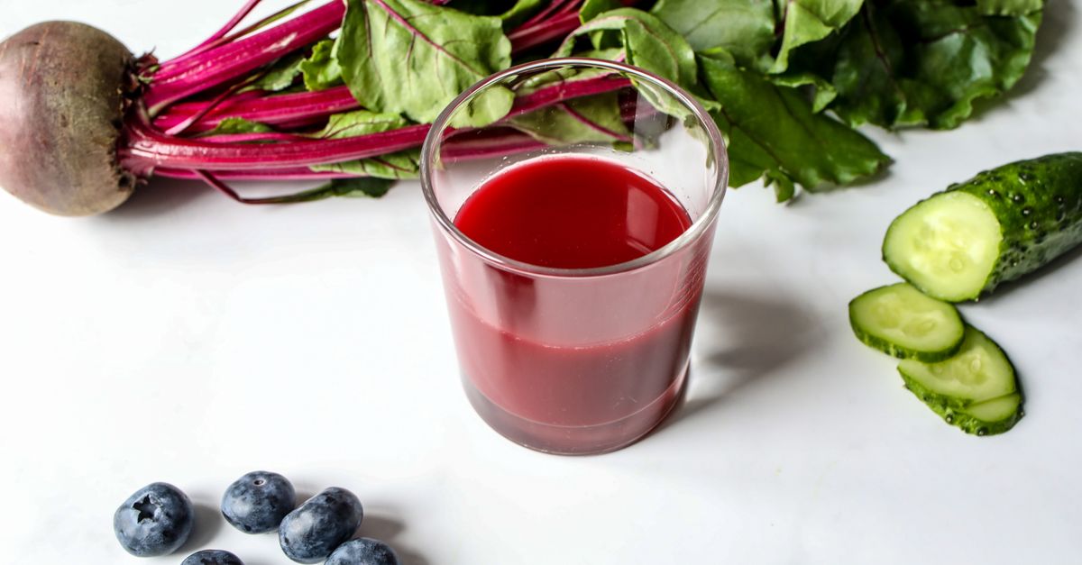 Glass of fresh beetroot juice with cucumbers and blueberries on a white background. - Evidence evidence guide for beetroot hydration exercise randomized trial