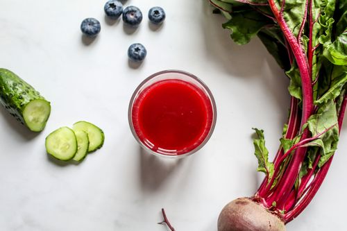 Free Top view of a vibrant beetroot juice with fresh cucumber and blueberries on a white background, perfect for a healthy lifestyle. Stock Photo