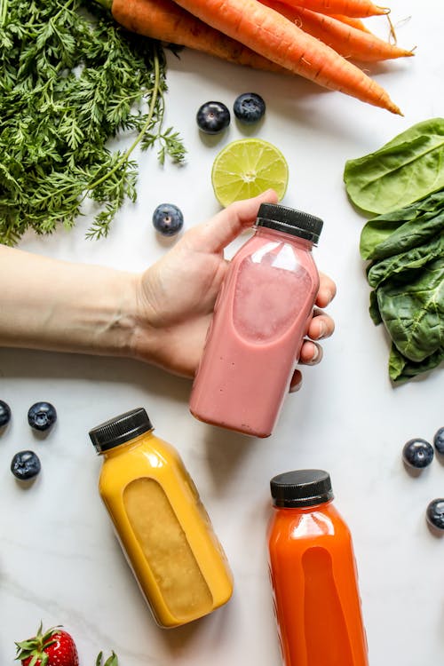 Free Person Holding Bottle with Smoothie Stock Photo