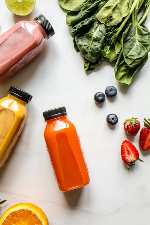 Smoothie in Bottles, Berries and Green Leaves 