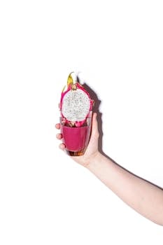 Bright dragon fruit smoothie held against a white background, showcasing freshness.