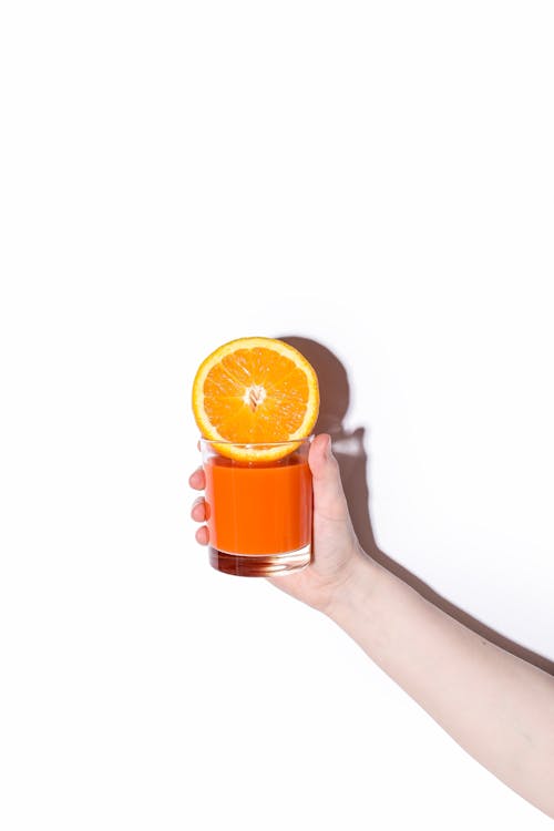Person Holding Glass with Orange Juice