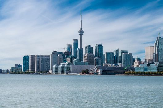 Stunning daytime view of Toronto skyline featuring the CN Tower and waterfront under a clear blue sky.