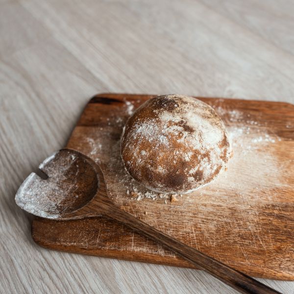 Rustic artisan bread on a flour-dusted wooden board — photo by Hana Brannigan on Pexels