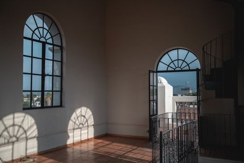 Free Sunlit interior room with arched windows in Guadalajara, Mexico, casting intricate shadows. Stock Photo