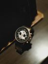 From above elegant male wristwatch with silver bracelet and stylish face placed on wooden table