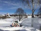 Snow cutter cleaning snowy road in countryside