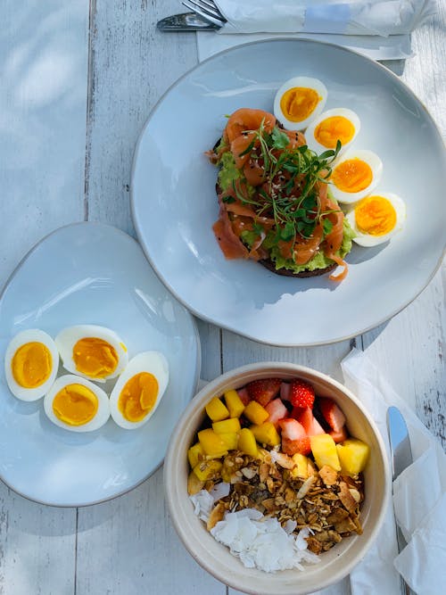 Healthy breakfast with boiled eggs sandwich and sliced fruits