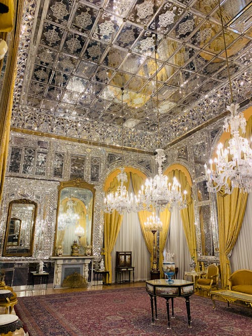 Interior design of spacious luxurious room of imperial palace with massive cut glass chandeliers carpet and classic furniture reflecting in mirror walls and ceiling