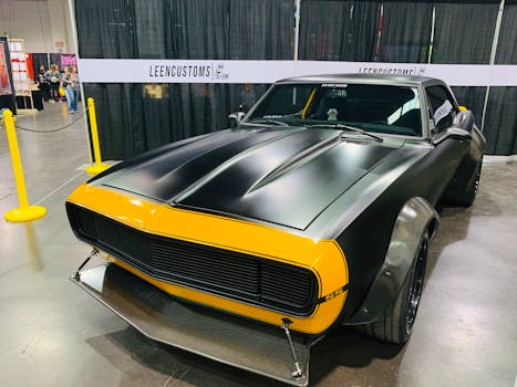 A matte black and yellow muscle car showcased indoors, featuring a modern design and luxury appeal.