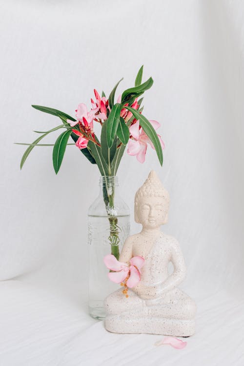 Foto profissional grátis de Buda, estatueta, flores cor-de-rosa