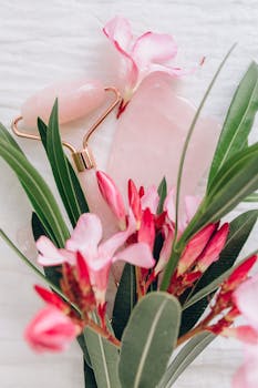 这幅美丽的静物画以挂沙工具、玉滚轴和充满活力的粉红色花朵为特色，背景为白色