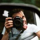 Young man showing tongue while taking photos and having fun