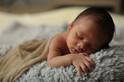 Baby Lying on Gray Fur Textile
