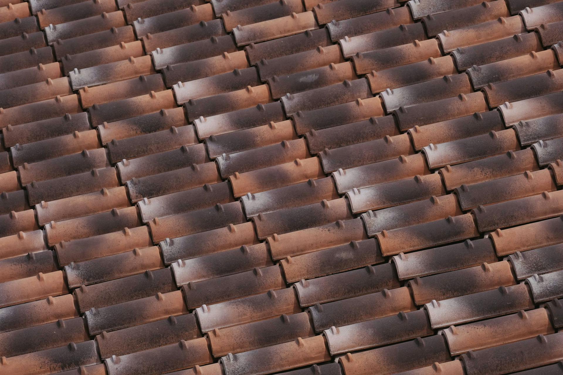 From above of shabby roof of house with tiled acute angled cross slab