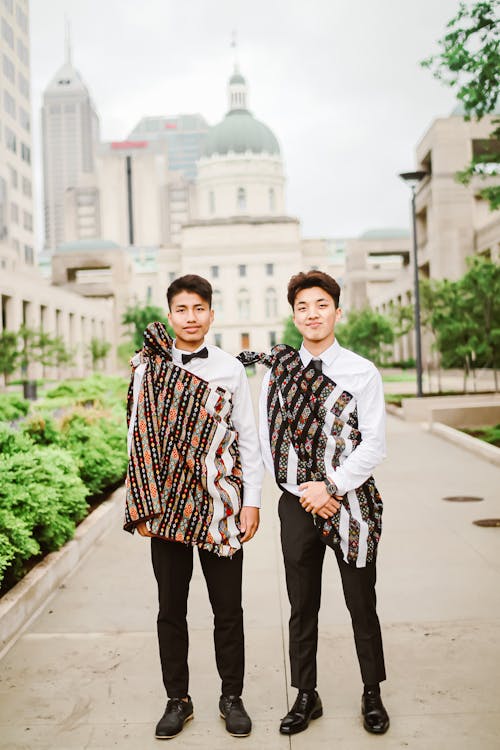 Smiling ethnic men in elegant clothes on street