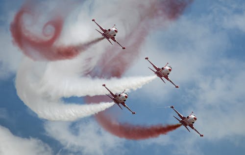 Free From below of flying fighters performing trick elements during air show in sunny day Stock Photo