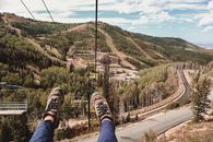Tourist riding down on ropeway in hilly terrain