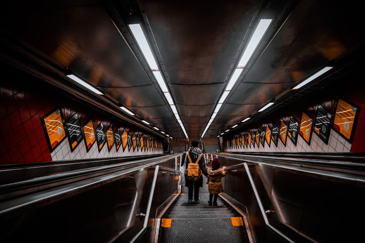 People Walking Down Steps In Subway