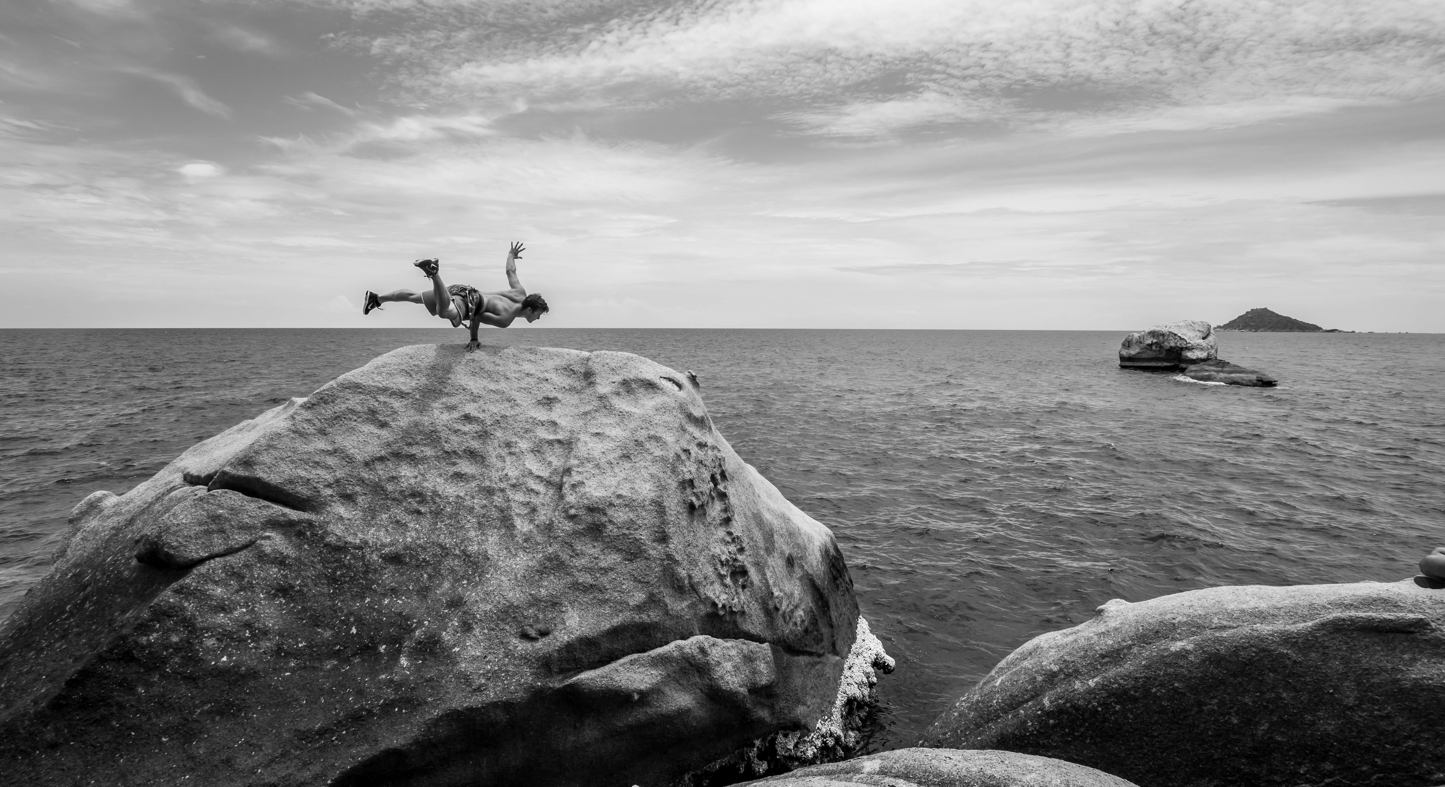 a person doing handstand on the rock