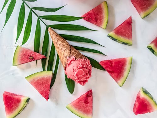Ice cream cone on leaf among watermelon wedge