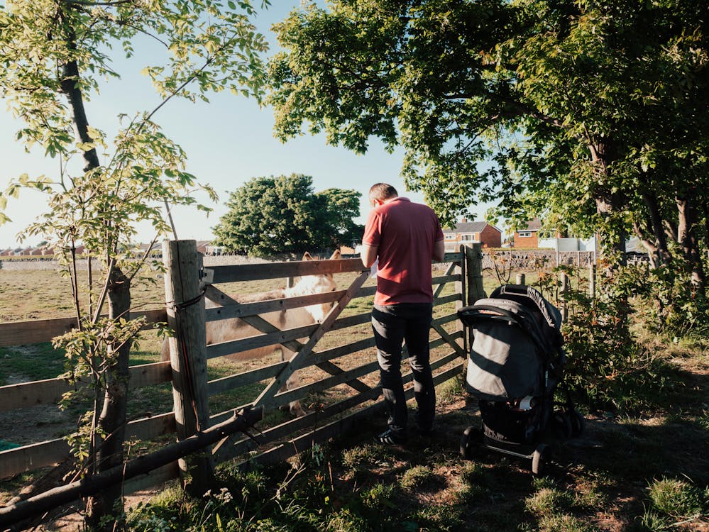 Photo of Man Standing Near Wooden Fence
