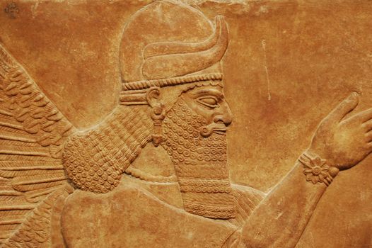 Detailed view of an ancient Assyrian relief sculpture showcasing intricate patterns in a museum in London.