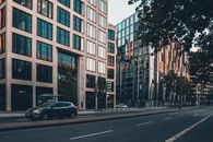 现代城市景观中，现代化办公楼与安静街道上的汽车