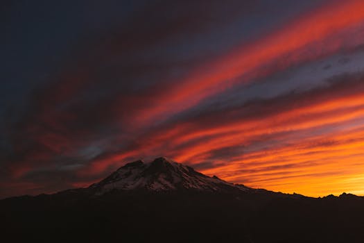 Breathtaking view of Mount Rainier at sunrise with vibrant sky hues.