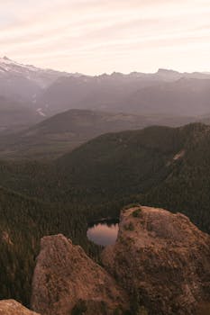 A stunning sunrise landscape of Mount Rainier National Park showcasing misty mountains and lush valleys.