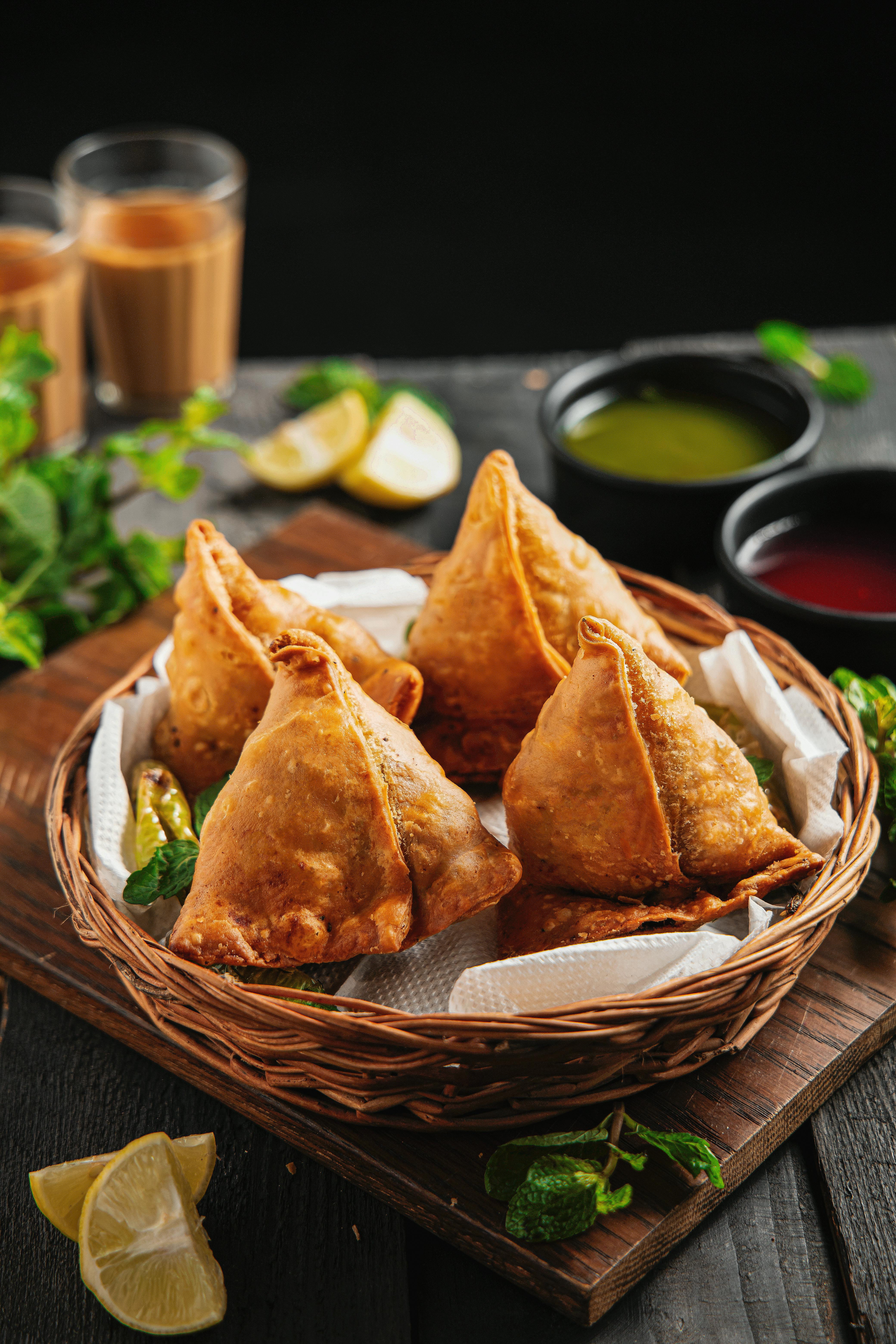 Samosas in wicker basket on dinner table · Free Stock Photo