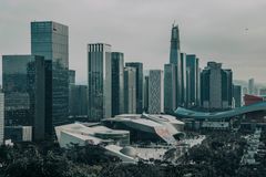 A modern urban skyline featuring numerous skyscrapers under a gloomy sky.