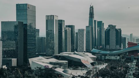 A modern urban skyline featuring numerous skyscrapers under a gloomy sky.