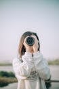 Woman in White Jacket Holding Black Lens