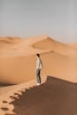 一名男子在晴朗的天空下，探索阿布扎比沙漠的巨大沙丘