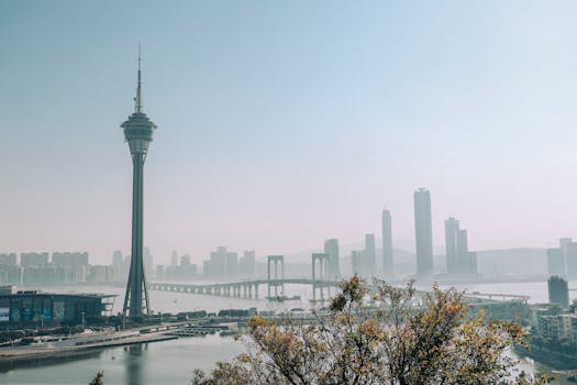 A beautiful urban skyline with a prominent tower and bridge under a clear sky, creating a serene cityscape.