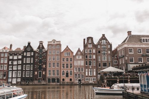 Free Classic Amsterdam canal scene with picturesque historic houses and boats. Stock Photo