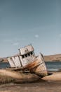 饱经风霜的船搁浅在加州海滩上，象征着时间和腐烂
