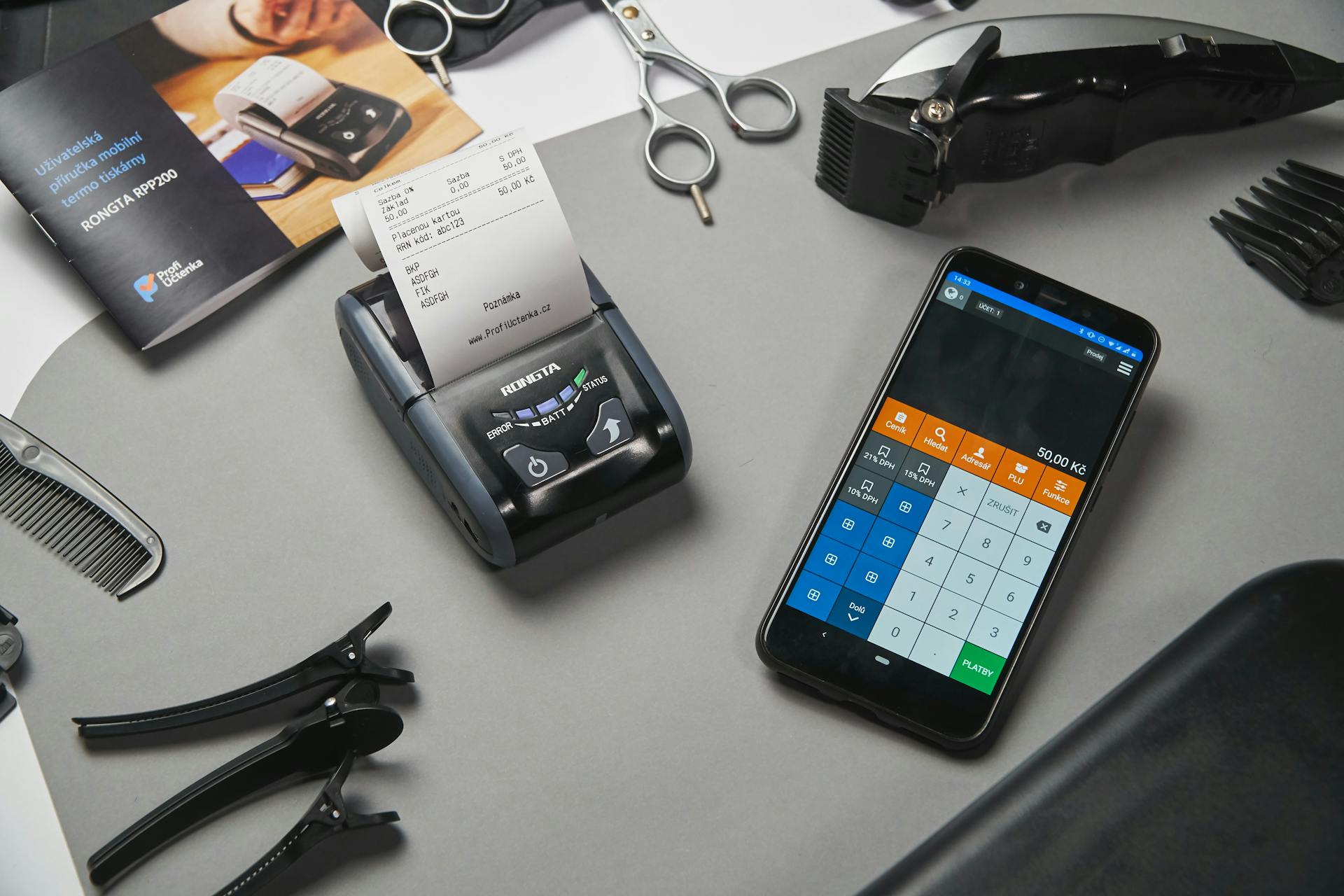 A mobile point-of-sale system in a barbershop featuring a smartphone and printer amidst salon tools.
