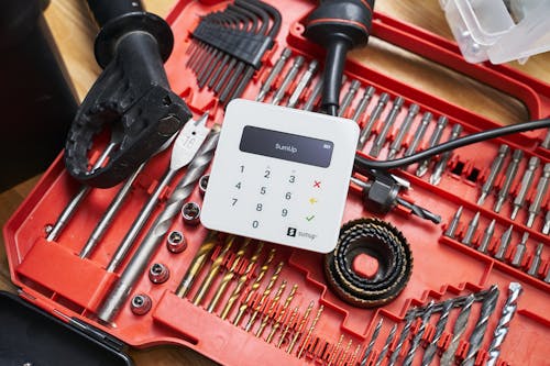 From above of contemporary white cash register on red organizer with metallic instruments