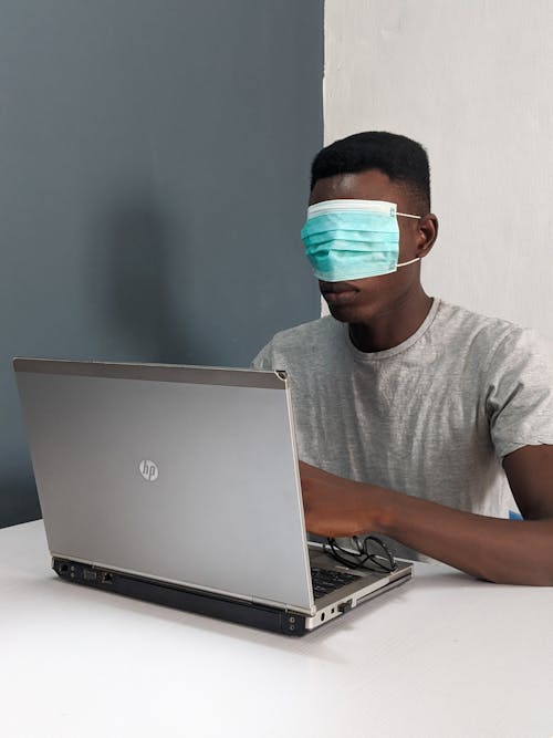 Kostenloses Stock Foto zu black male, chirurgische maske, computer