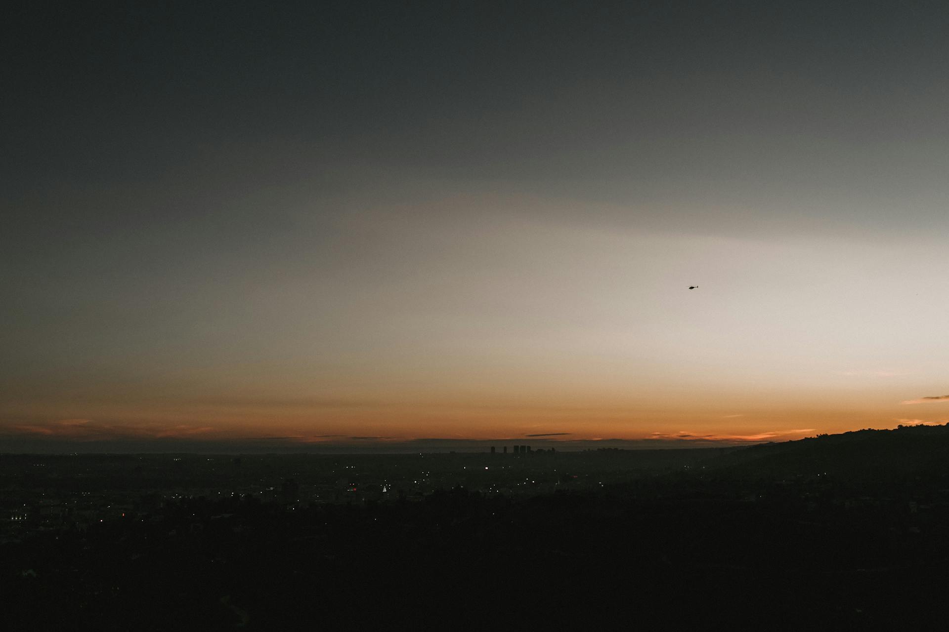 Silhouette of San Francisco cityscape at dusk with a dramatic sky overhead.