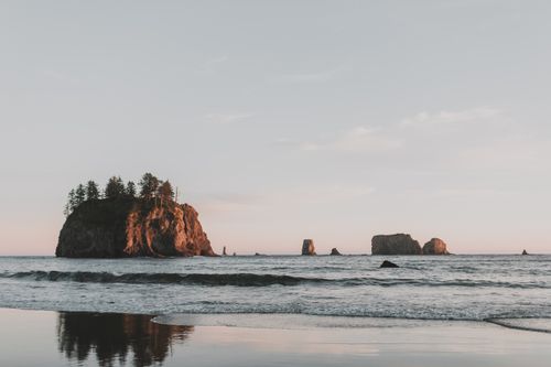Free Beautiful sunset over rocky seascape with ocean waves and island formations in Washington. Stock Photo