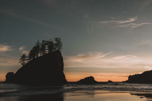 Free Tranquil seascape at sunset with rock formations and silhouettes along the Washington coastline. Stock Photo