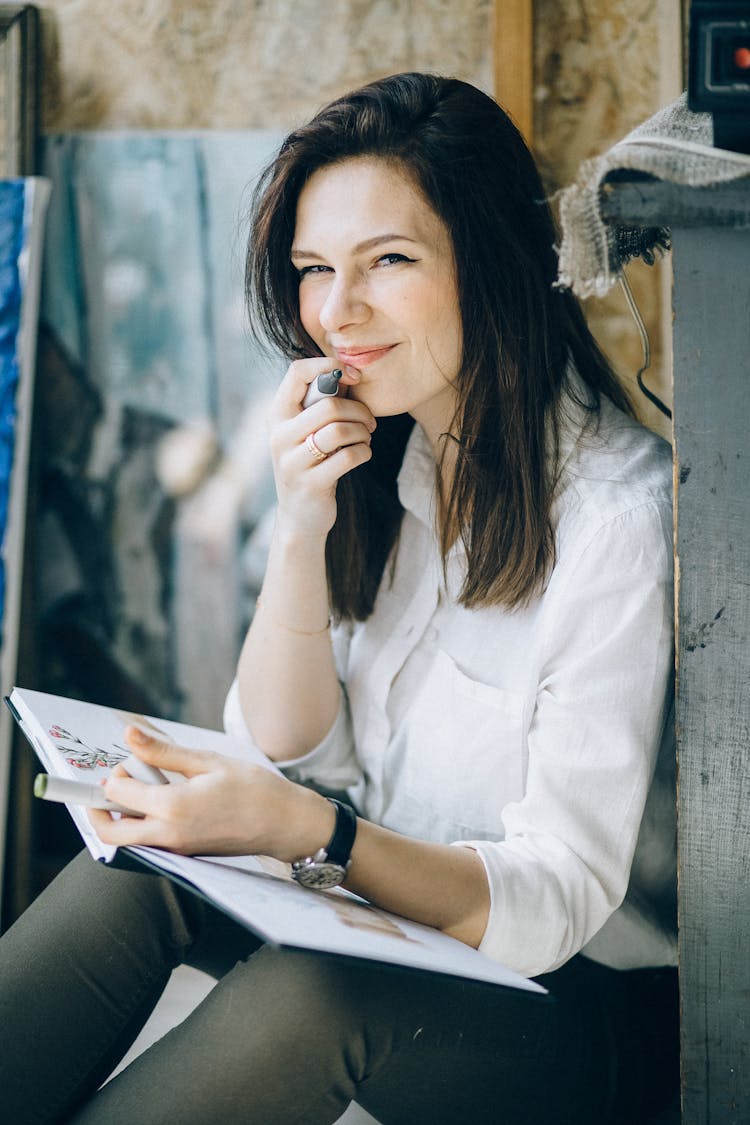 Woman In White Long Sleeve Shirt Holding White Book